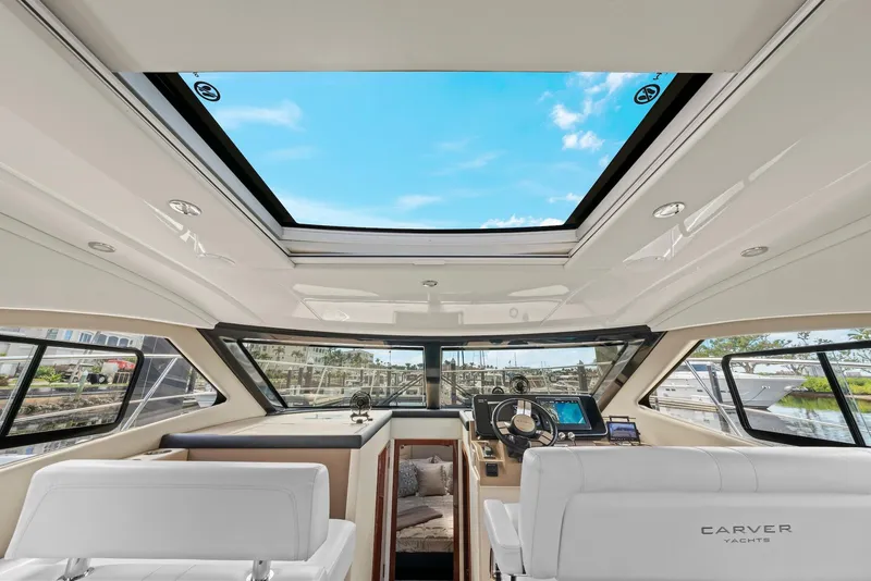 Slide: The Image of Interior view of 2016 Carver C37 Coupe yacht with panoramic windows and modern helm. - 45