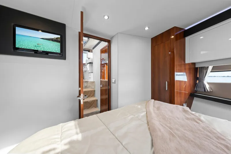 Slide: The Image of Interior of 2016 Carver C37 Coupe yacht bedroom with TV and wooden cabinetry. - 49