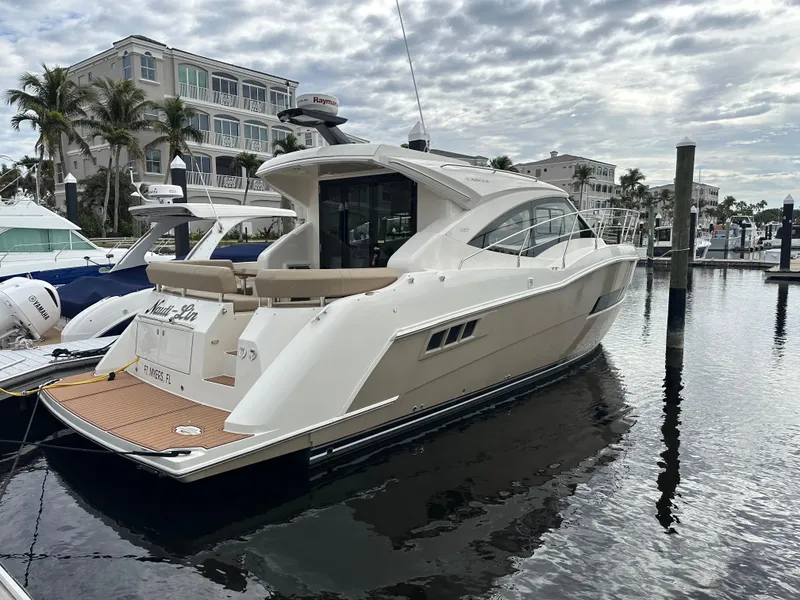 Slide: The Image of 2016 Carver C37 Coupe yacht docked at marina, cloudy sky background. - 14