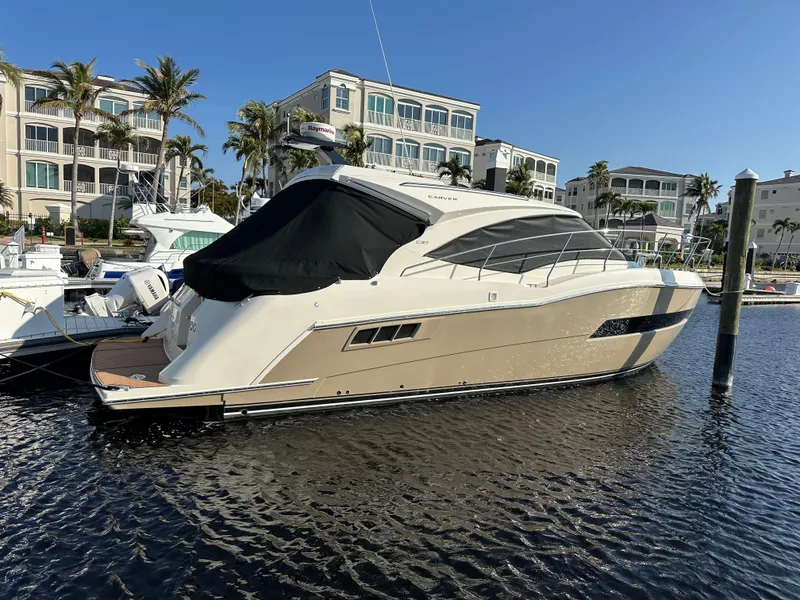 Slide: The Image of 2016 Carver C37 Coupe yacht docked in marina, surrounded by luxury buildings. - 15