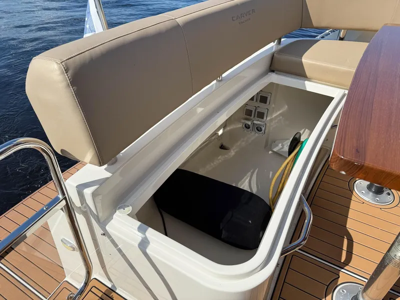 Slide: The Image of 2016 Carver C37 Coupe storage compartment with beige seating and wooden deck. - 23