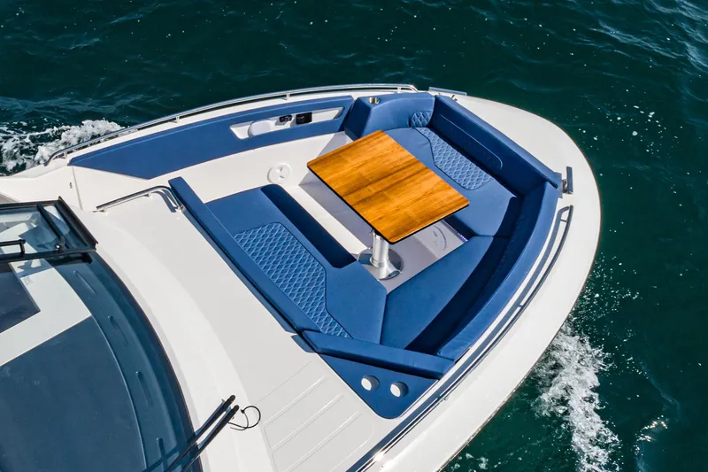 Slide: The Image of Bavaria Vida 33 boat, 2023 model, featuring blue seating and a wooden table on deck. - 26