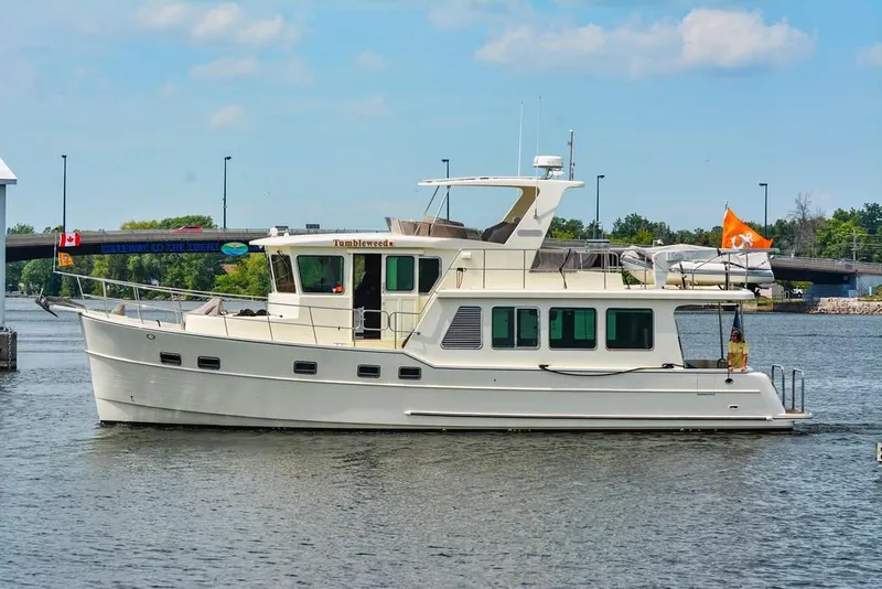 Slide: The Image of 2016 North Pacific 49 Pilothouse yacht on a calm river. - 1