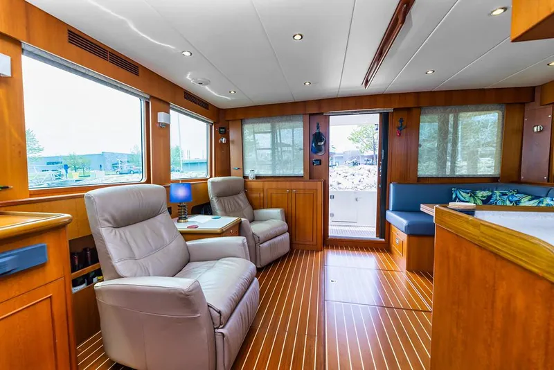Slide: The Image of Luxurious interior of 2016 North Pacific 49 Pilothouse yacht with plush seating and wood flooring. - 10