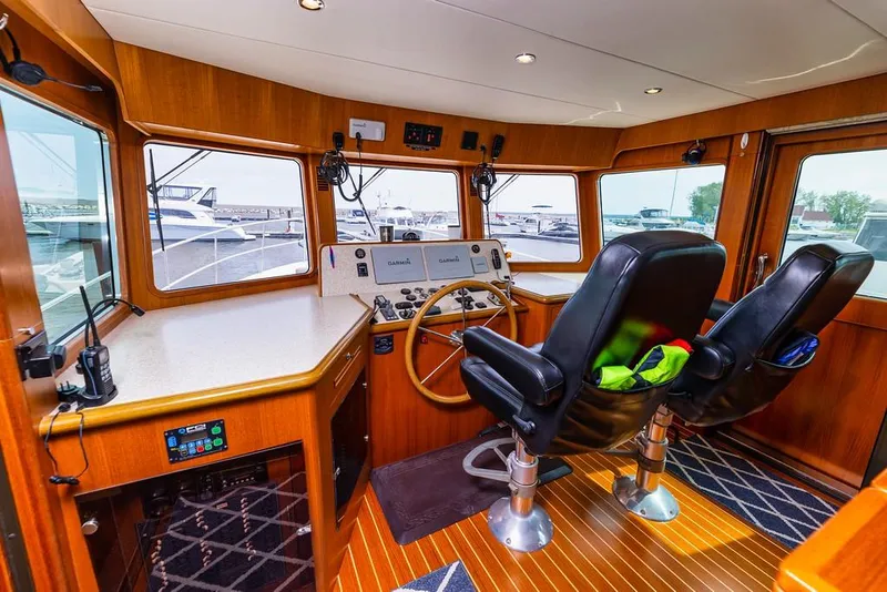 Slide: The Image of Interior of 2016 North Pacific 49 Pilothouse with helm and navigation equipment. - 13