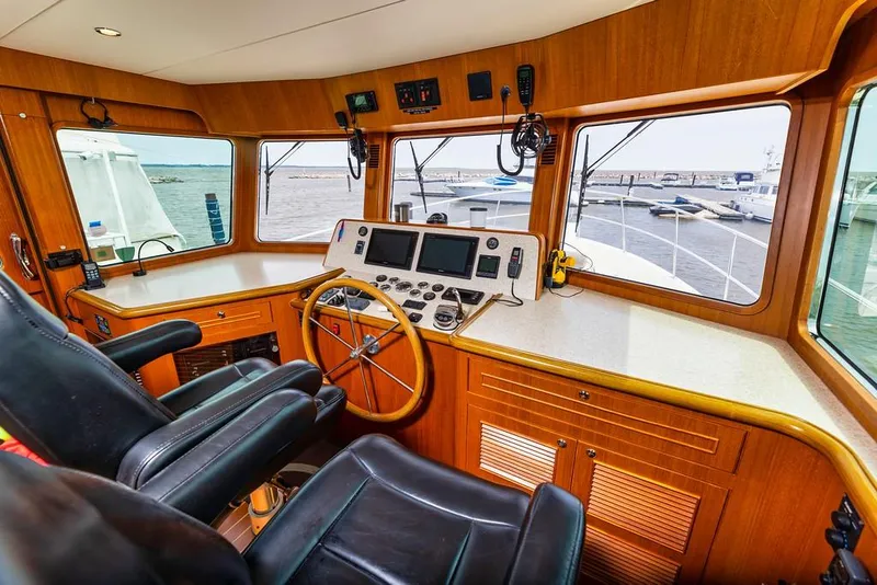 Slide: The Image of Interior of 2016 North Pacific 49 Pilothouse with steering wheel and navigation equipment. - 14