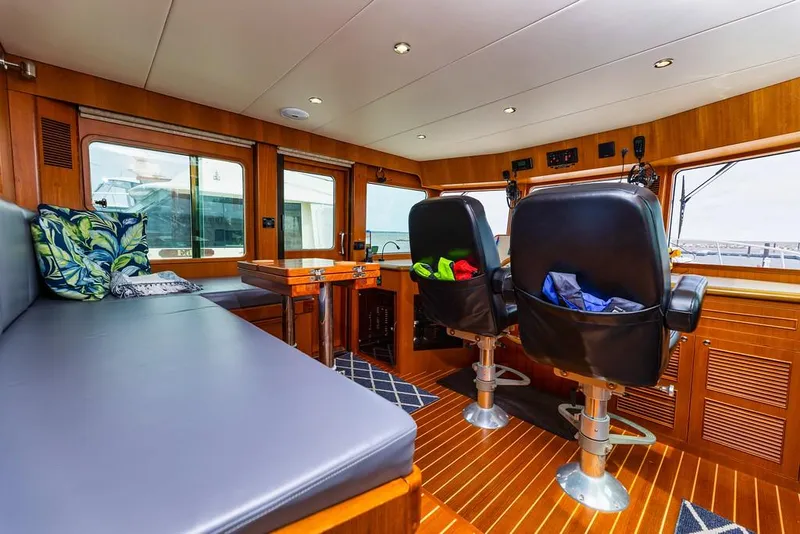 Slide: The Image of Interior of 2016 North Pacific 49 Pilothouse with seating and navigation area. - 16