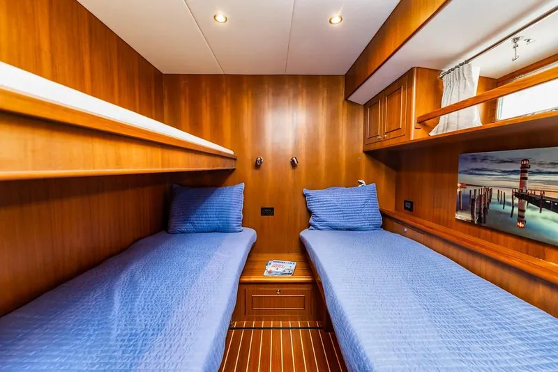 Slide: The Image of Twin cabin with blue bedding in 2016 North Pacific 49 Pilothouse yacht. - 18