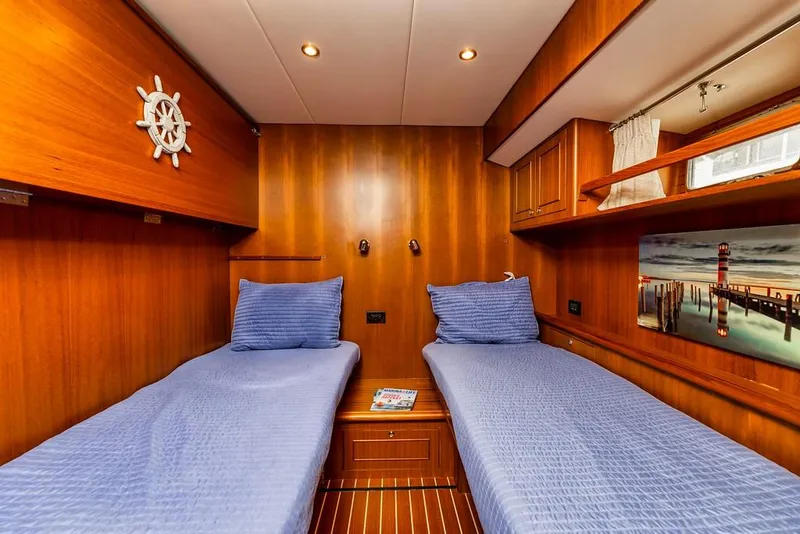 Slide: The Image of Cozy twin cabin in 2016 North Pacific 49 Pilothouse yacht with wood paneling and blue bedding. - 19