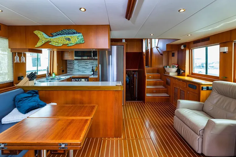 Slide: The Image of Luxurious interior of 2016 North Pacific 49 Pilothouse yacht with modern kitchen and seating area. - 2