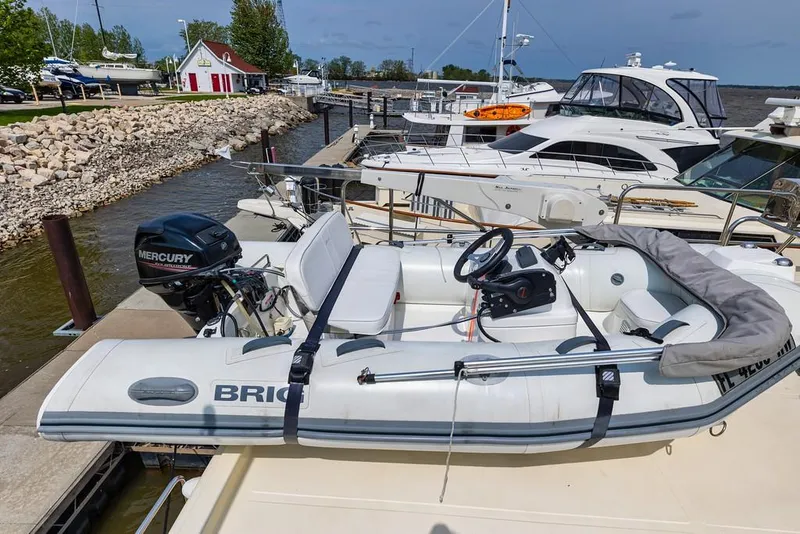 Slide: The Image of 2016 North Pacific 49 Pilothouse docked with inflatable boat and Mercury engine. - 29