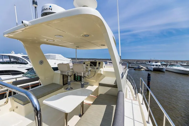 Slide: The Image of 2016 North Pacific 49 Pilothouse yacht with spacious deck and seating area. - 32
