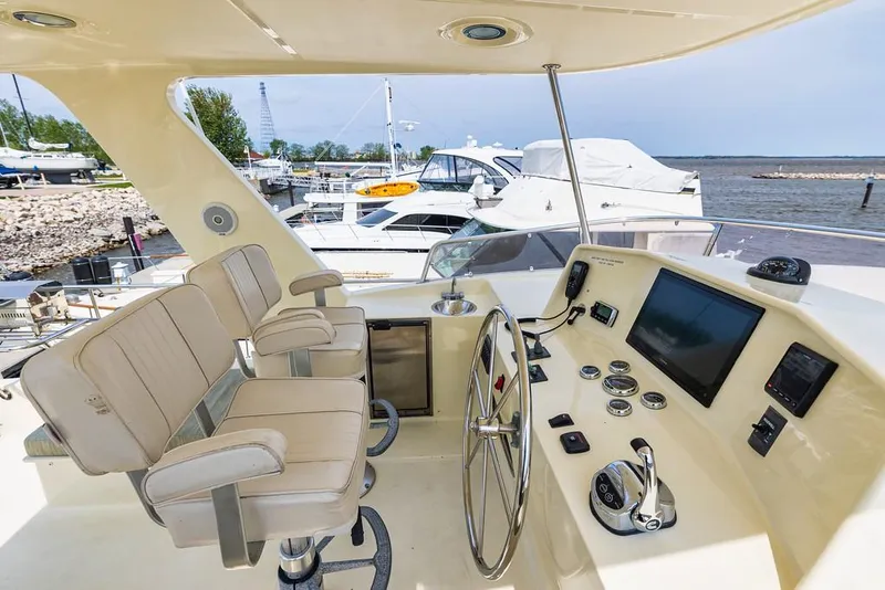 Slide: The Image of 2016 North Pacific 49 Pilothouse helm with dual seats and navigation equipment. - 33