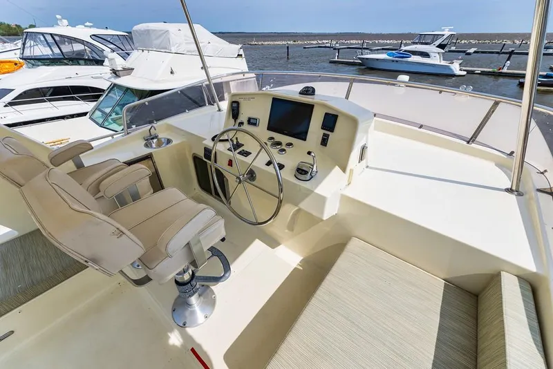 Slide: The Image of 2016 North Pacific 49 Pilothouse helm with modern controls and seating, docked at marina. - 34