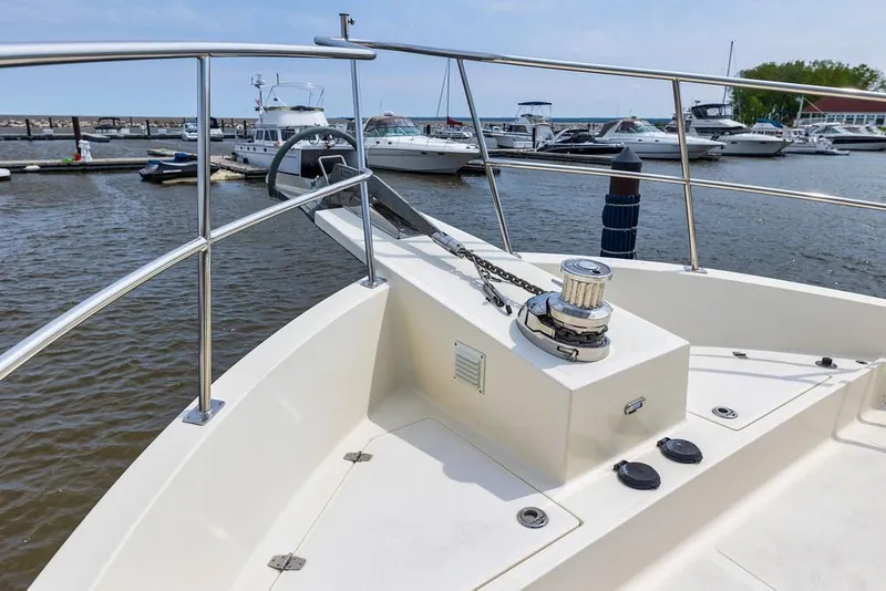 Slide: The Image of North Pacific 49 Pilothouse 2016 yacht bow at marina, featuring anchor and railing. - 36