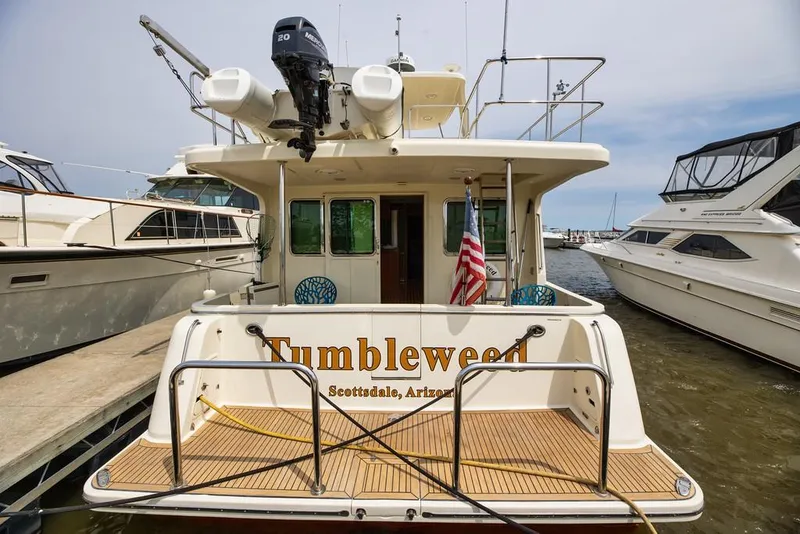 Slide: The Image of 2016 North Pacific 49 Pilothouse yacht docked, rear view with American flag. - 38