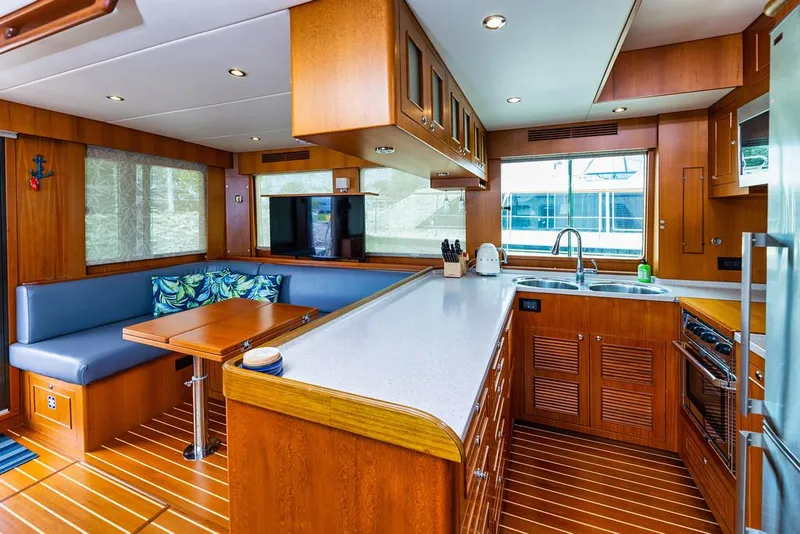 Slide: The Image of Luxurious 2016 North Pacific 49 Pilothouse yacht interior with modern kitchen and dining area. - 8