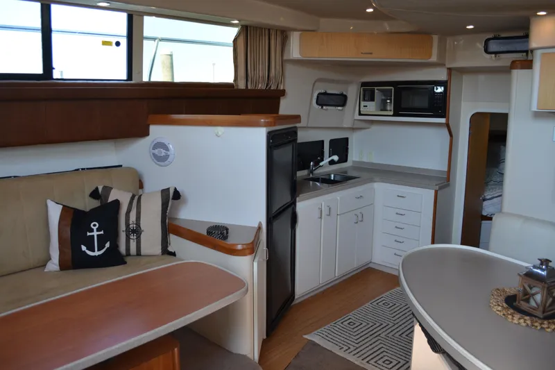 Slide: The Image of Interior of 1995 Mainship 37 Motor Yacht with kitchen and seating area. - 12