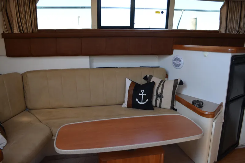 Slide: The Image of Interior of 1995 Mainship 37 Motor Yacht with beige seating and nautical-themed decor. - 13