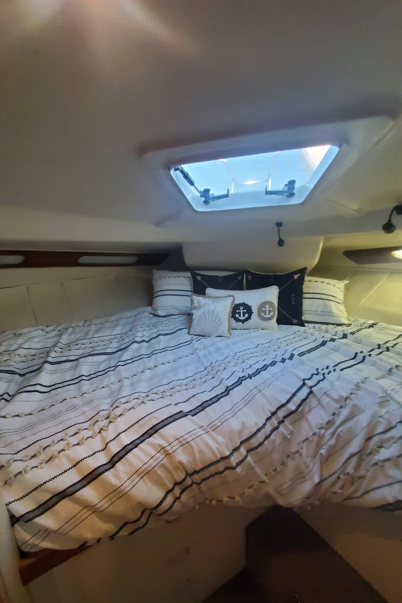 Slide: The Image of Cozy cabin interior of 1995 Mainship 37 Motor Yacht with striped bedding and nautical decor. - 22