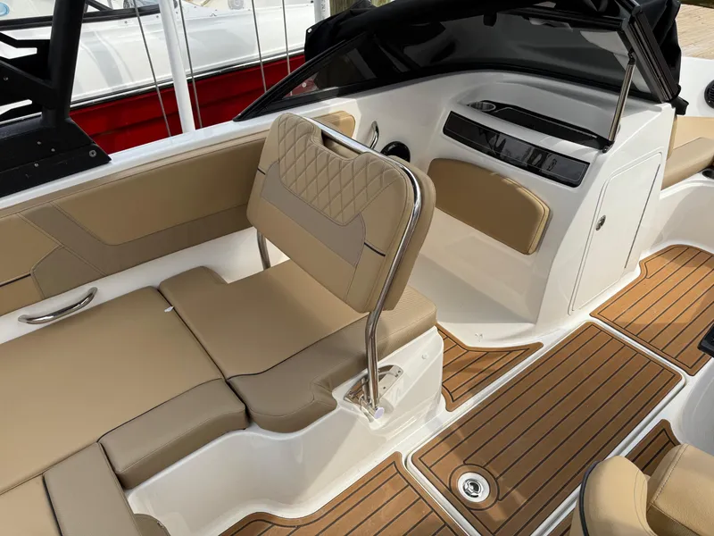Slide: The Image of 2025 Bayliner VR5 Bowrider OB interior with tan seating and wood-style flooring. - 8