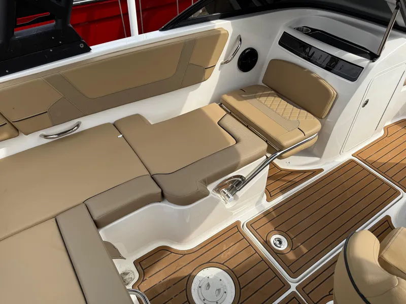 Slide: The Image of 2025 Bayliner VR5 Bowrider OB interior with tan seating and wood-style flooring. - 9