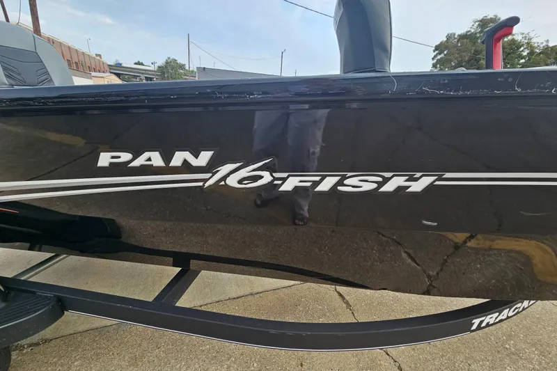 Slide: The Image of 2019 Tracker Panfish 16 boat, black exterior with logo, parked on pavement. - 4