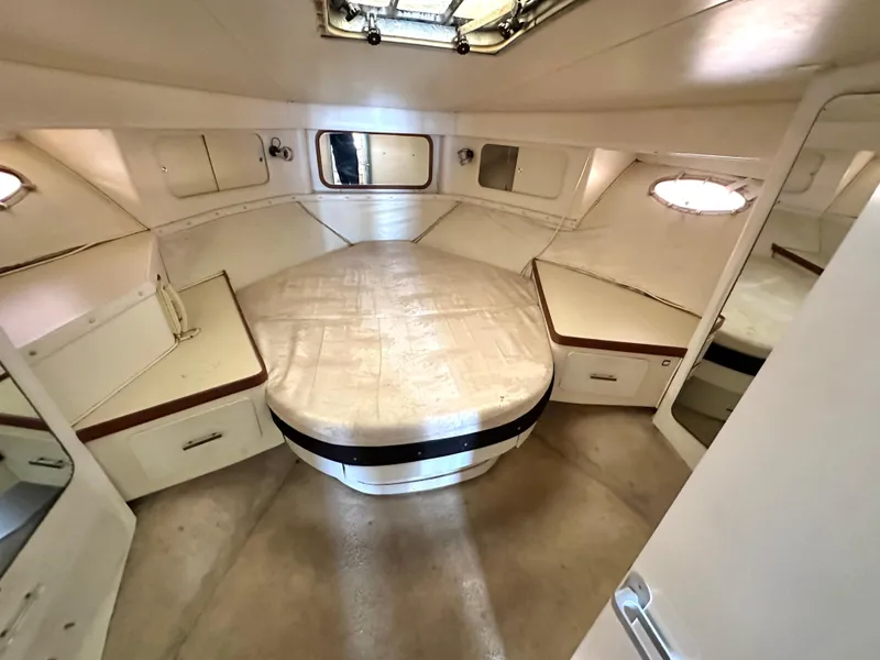 Slide: The Image of Interior cabin of 1990 Trojan 46 Flybridge yacht, featuring a spacious bed and storage. - 15