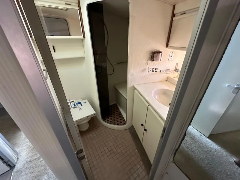Slide: The Image of Bathroom interior of 1990 Trojan 46 Flybridge yacht, featuring sink, toilet, and shower. - 16