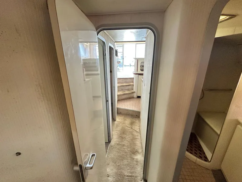 Slide: The Image of Interior hallway of a 1990 Trojan 46 Flybridge yacht, featuring carpeted flooring and modern design. - 17