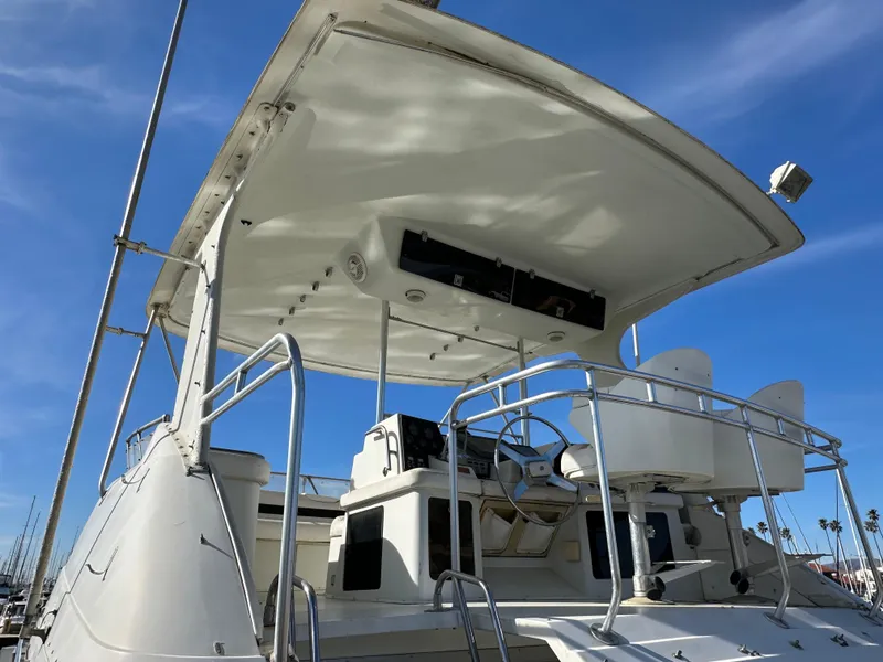 Slide: The Image of 1990 Trojan 46 Flybridge yacht with helm, under clear blue sky. - 25