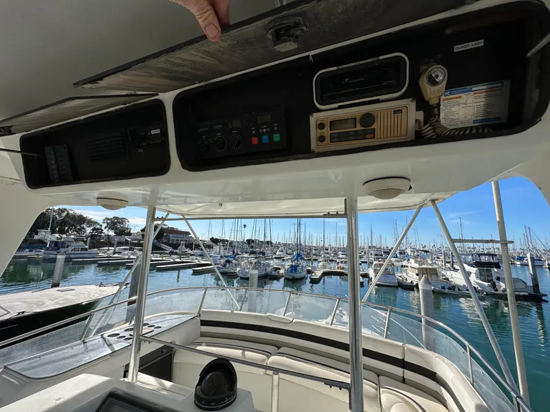 Slide: The Image of Control panel of a 1990 Trojan 46 Flybridge yacht overlooking a marina. - 26
