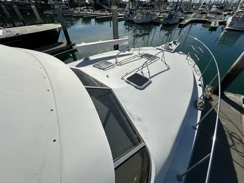 Slide: The Image of 1990 Trojan 46 Flybridge yacht docked at marina, top deck view. - 29