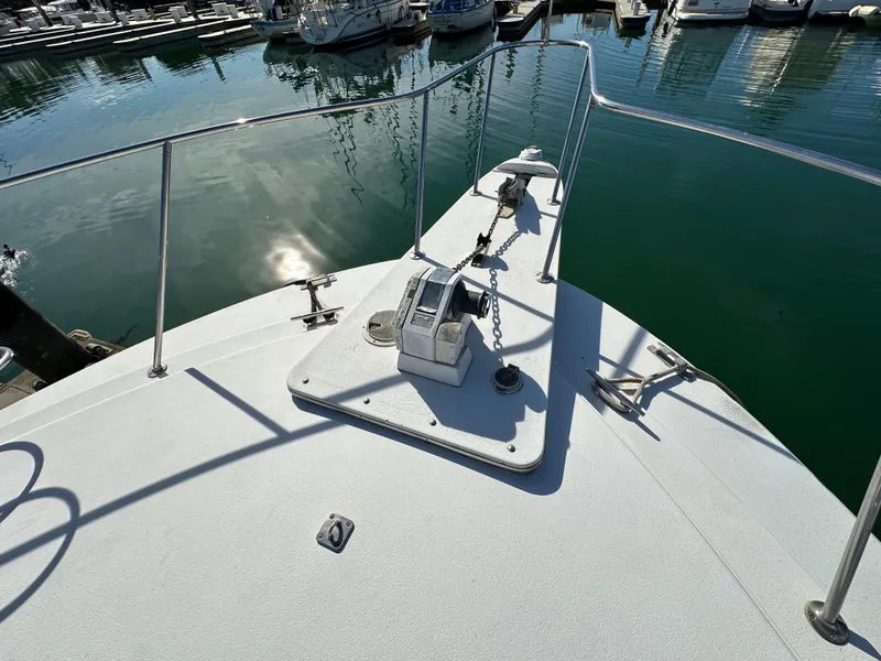 Slide: The Image of 1990 Trojan 46 Flybridge yacht bow with anchor, docked in marina. - 31