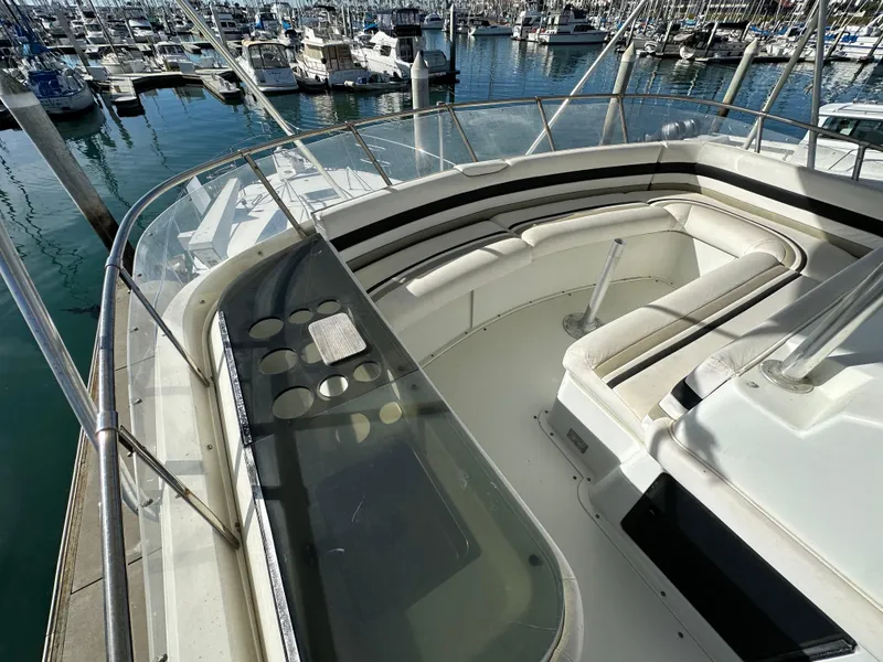 Slide: The Image of 1990 Trojan 46 Flybridge yacht with spacious seating, docked in a marina. - 33