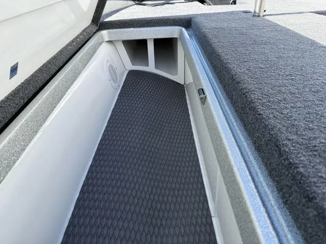 Slide: The Image of Phoenix 21 XE 2025 boat storage compartment with carpeted interior and speaker. - 13