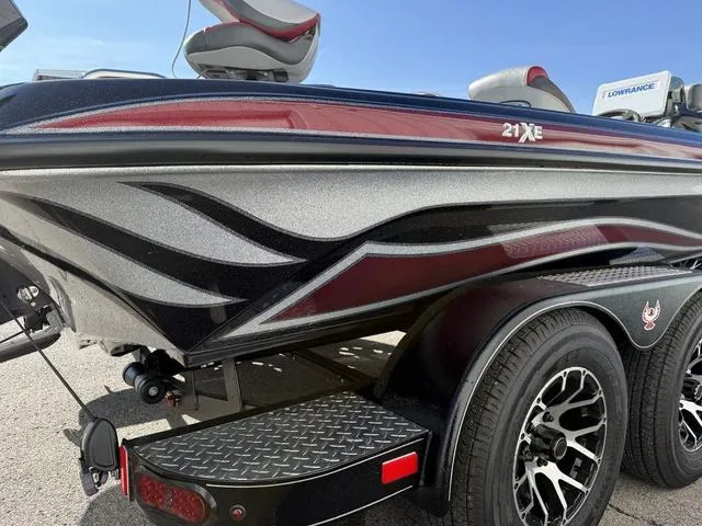 Slide: The Image of 2025 Phoenix 21 XE boat with sleek design and custom graphics on trailer. - 25