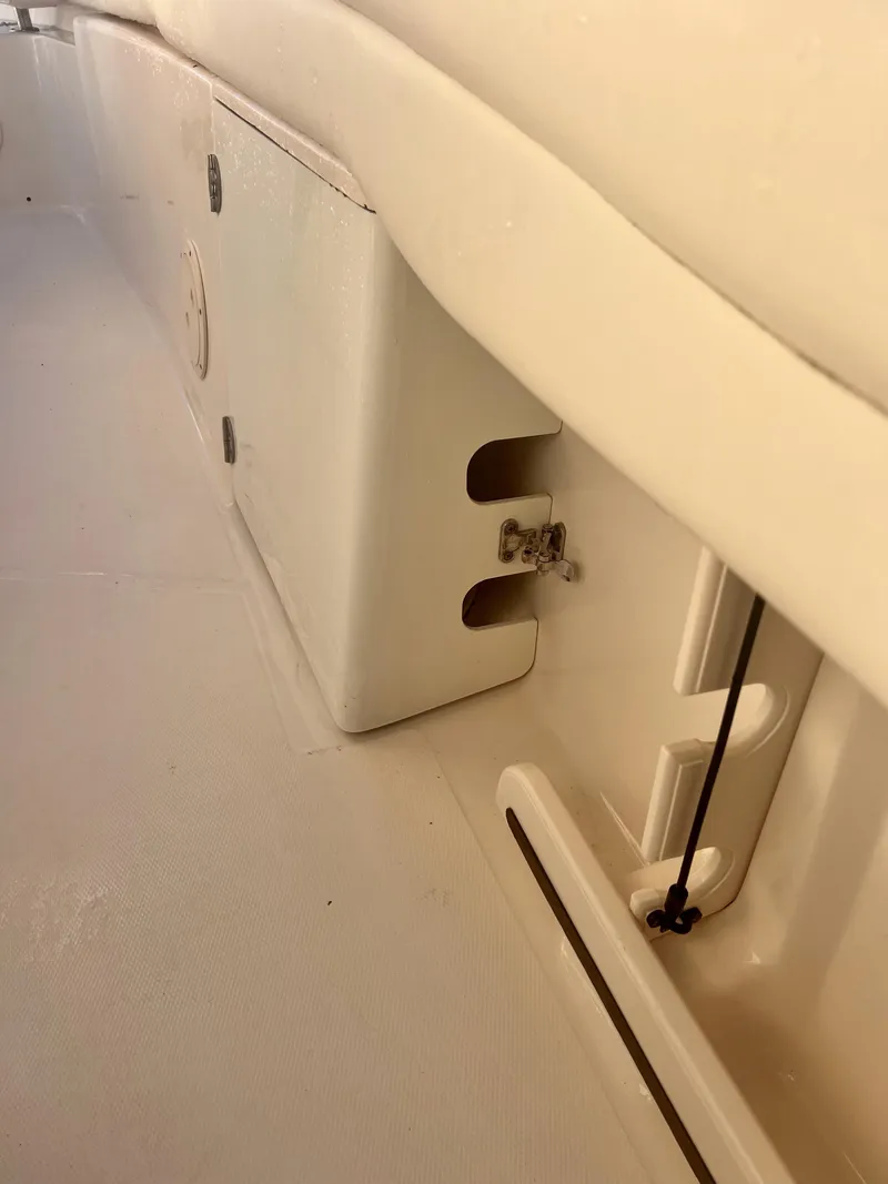 Slide: The Image of 2018 Grady-White Canyon 271 FS interior detail, showcasing storage compartment and seating area. - 15