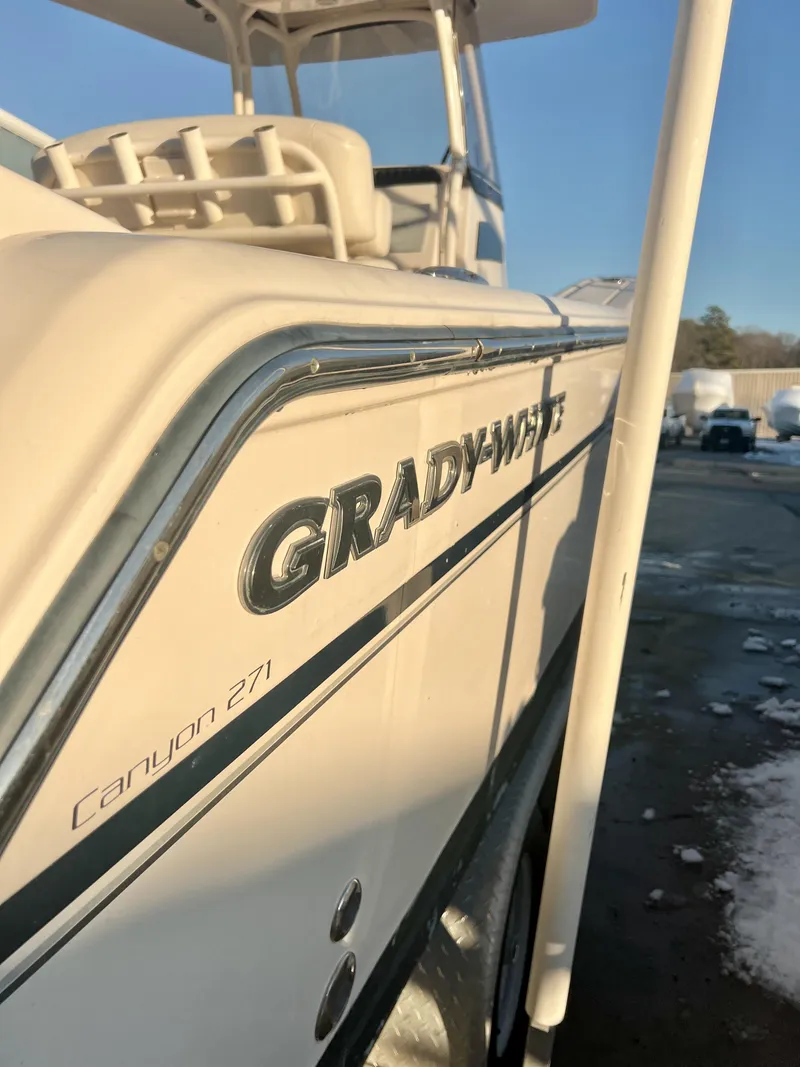 Slide: The Image of 2018 Grady-White Canyon 271 FS boat, side view with logo and model name. - 2
