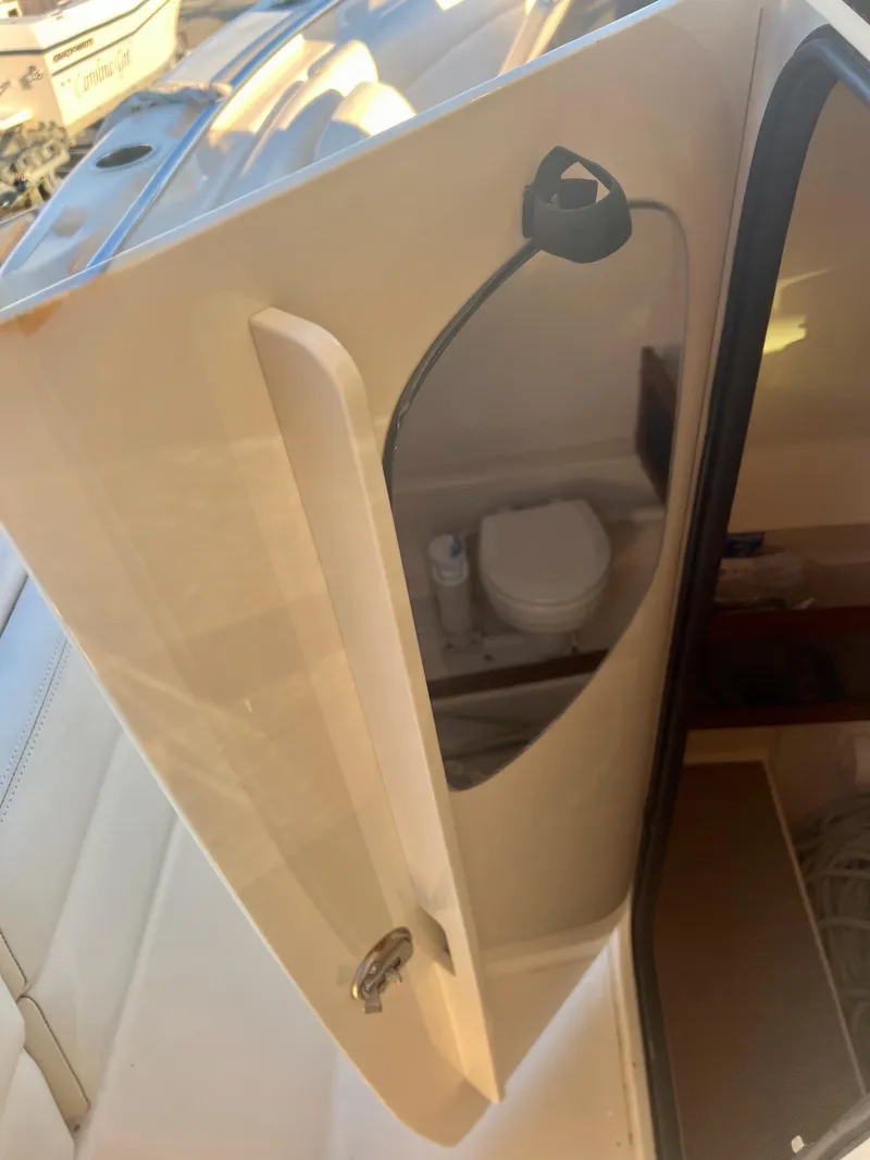 Slide: The Image of 2018 Grady-White Canyon 271 FS boat interior with a view of the bathroom. - 26
