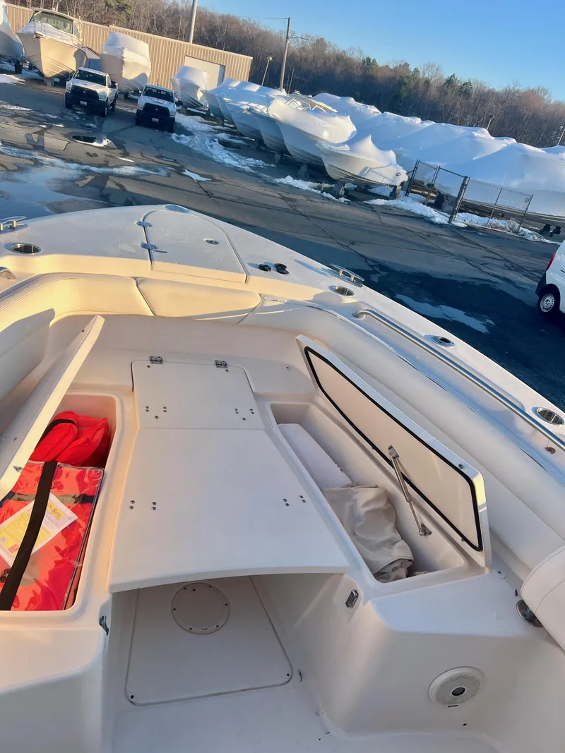 Slide: The Image of 2018 Grady-White Canyon 271 FS boat with open storage compartments, docked outdoors. - 37