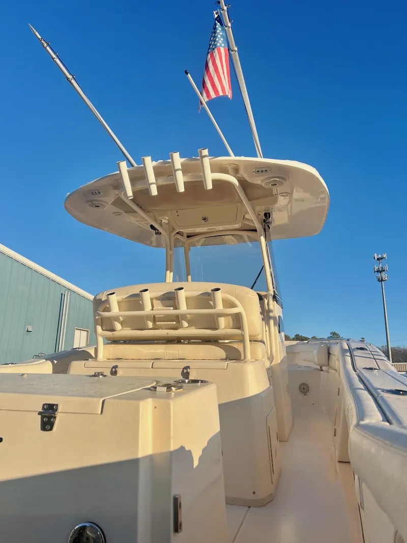 Slide: The Image of 2018 Grady-White Canyon 271 FS boat with American flag, clear blue sky background. - 9