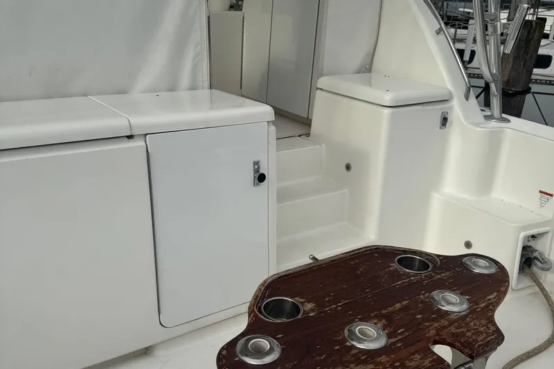 Slide: The Image of 2004 Tiara Yachts 4200 Open cockpit with white seating and wooden table. - 10