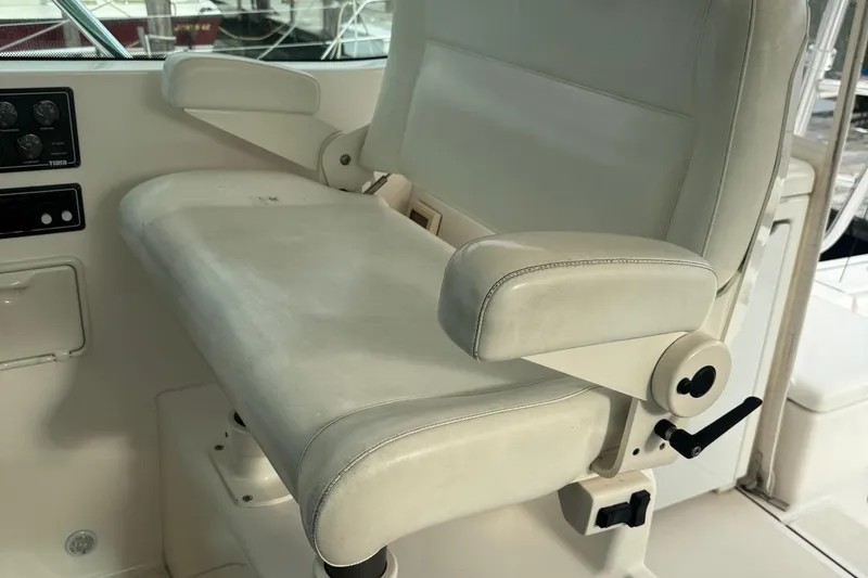Slide: The Image of Captain's chair on 2004 Tiara Yachts 4200 Open, featuring white upholstery and adjustable armrests. - 18