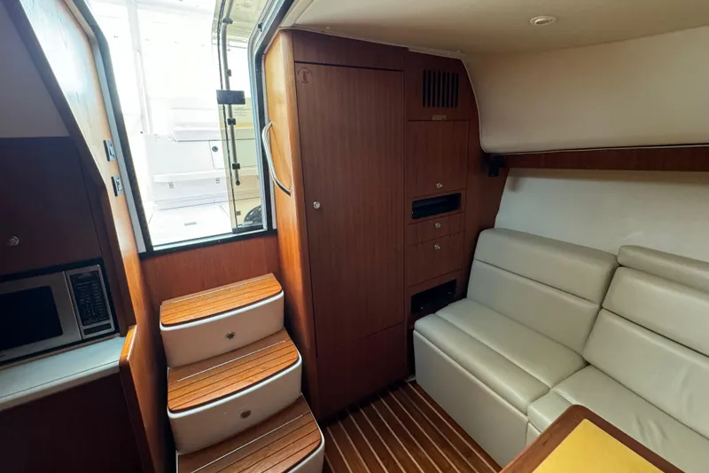 Slide: The Image of Interior of 2004 Tiara Yachts 4200 Open, featuring wooden cabinetry and white seating. - 30
