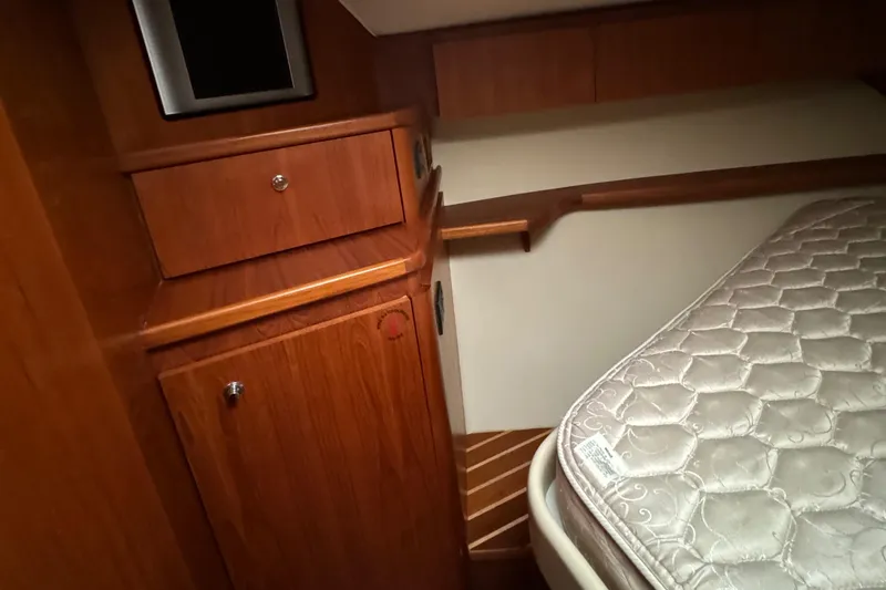 Slide: The Image of Tiara Yachts 4200 Open 2004 cabin interior with wooden cabinetry and mattress. - 39