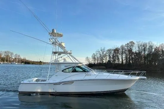 Slide: The Image of 2004 Tiara Yachts 4200 Open cruising on a calm lake under a clear blue sky. - 4