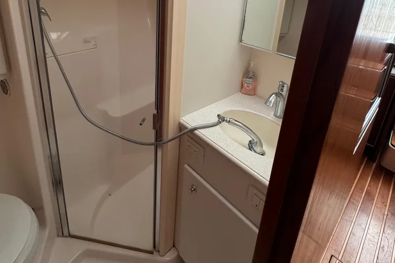 Slide: The Image of 2004 Tiara Yachts 4200 Open bathroom with shower, sink, and wooden flooring. - 40