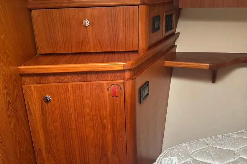 Slide: The Image of 2004 Tiara Yachts 4200 Open interior with wooden cabinetry and fire extinguisher compartment. - 42