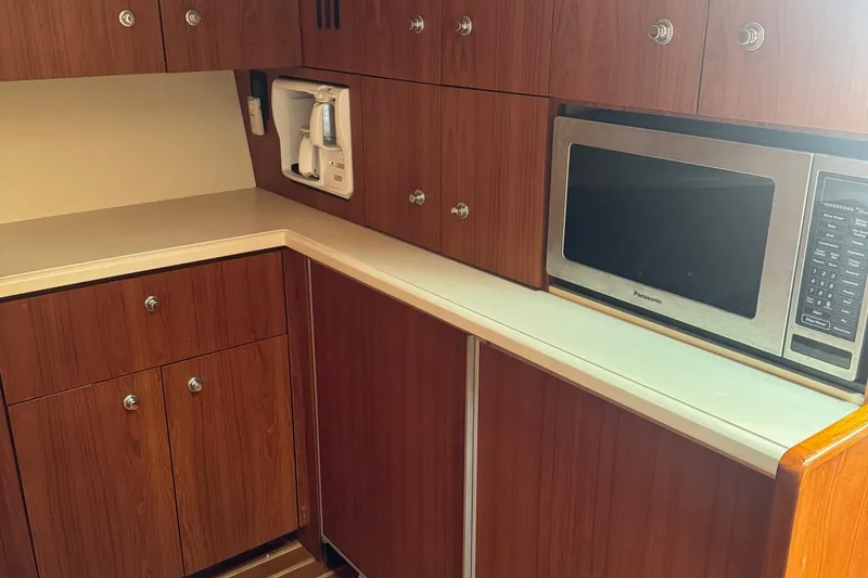Slide: The Image of 2004 Tiara Yachts 4200 Open galley with wood cabinets, microwave, and coffee maker. - 44